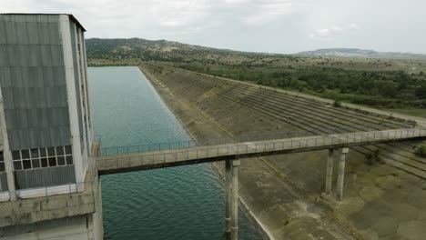 Torre-De-Control-Desolada-Con-Puente-Y-Muro-De-Presa-De-Hormigón,-Embalse-De-Dali