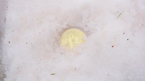 Männliche-Hand,-Die-Goldenes-Bitcoin-Aus-Dem-Schnee-Gräbt