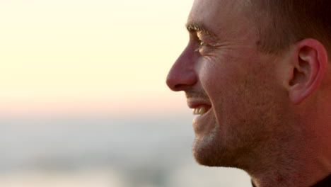 perfil de primer plano de un rostro masculino disfrutando de la puesta de sol