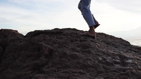 Woman-Walking-On-Coastal-Rocks-On-The-Beach---tracking-shot