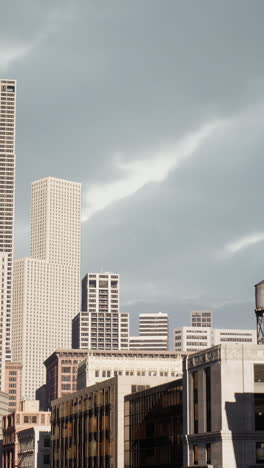 city skyline with tall buildings and cloudy sky