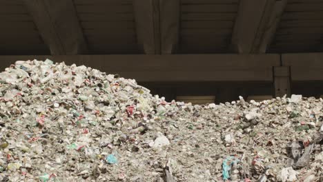 mountain with dunes of trash, dunes of bottles, cans, cans, glass, stones, shards, ceramics, windows, bars, aluminum, and other waste ready to be recycled, sunlit