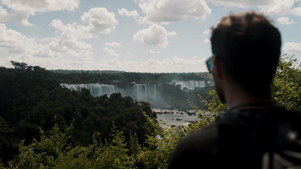 un mochilero apreciando la naturaleza en las cataratas de iguazu en argentina - toma media