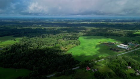 bajo un cielo nublado, una vasta y impresionante perspectiva aérea revela ciudades, campos exuberantes y bosques, creando un paisaje majestuoso y cinematográfico