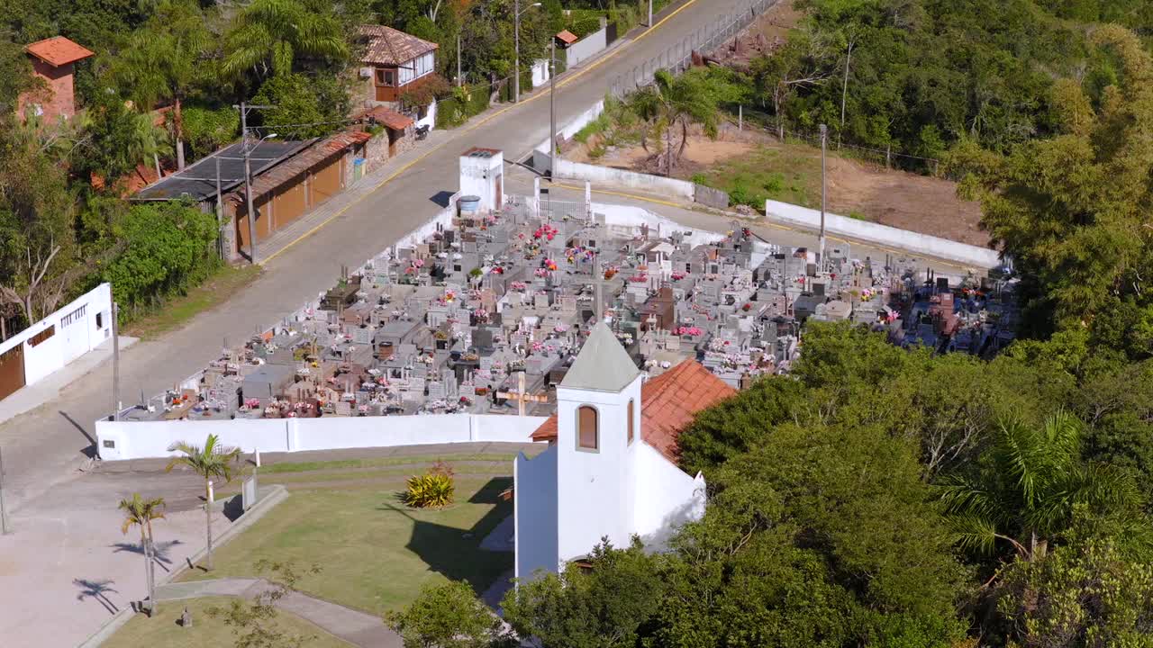 Aerial perspective of local cemetery of Saudade municipality with white small chapel, Bombinhas, Santa Catarina, Brazil