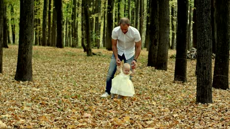 father and his baby make first step in autumn park