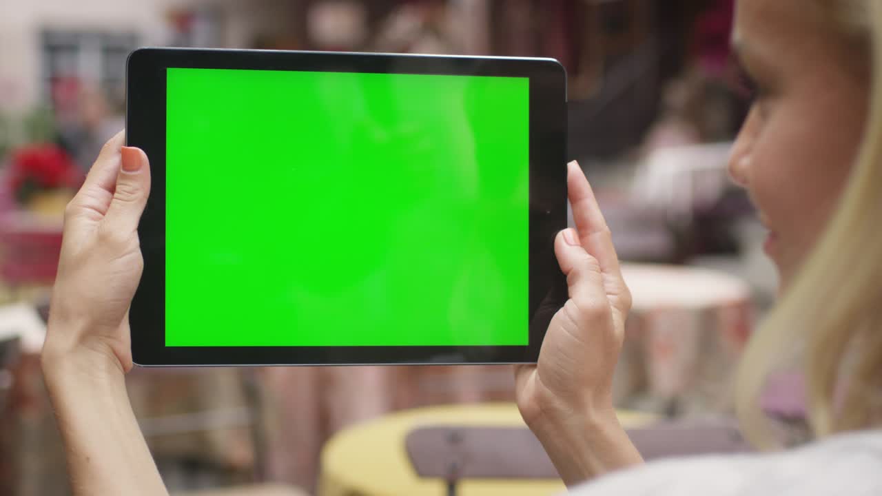 la chica tiene una tableta pc en modo paisaje en una cafetería al aire libre