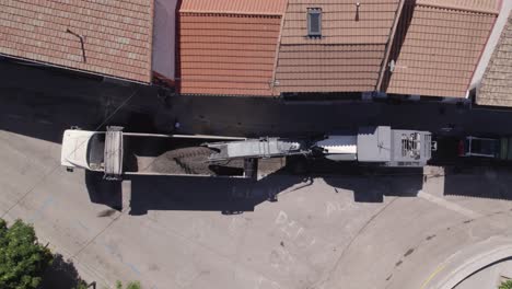 road milling machine removing tarmac and loading it into back of dump truck in navas del rey street in spain