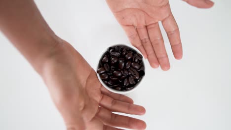 vista de arriba hacia abajo de los granos de café esparcidos por el tazón blanco mientras gira