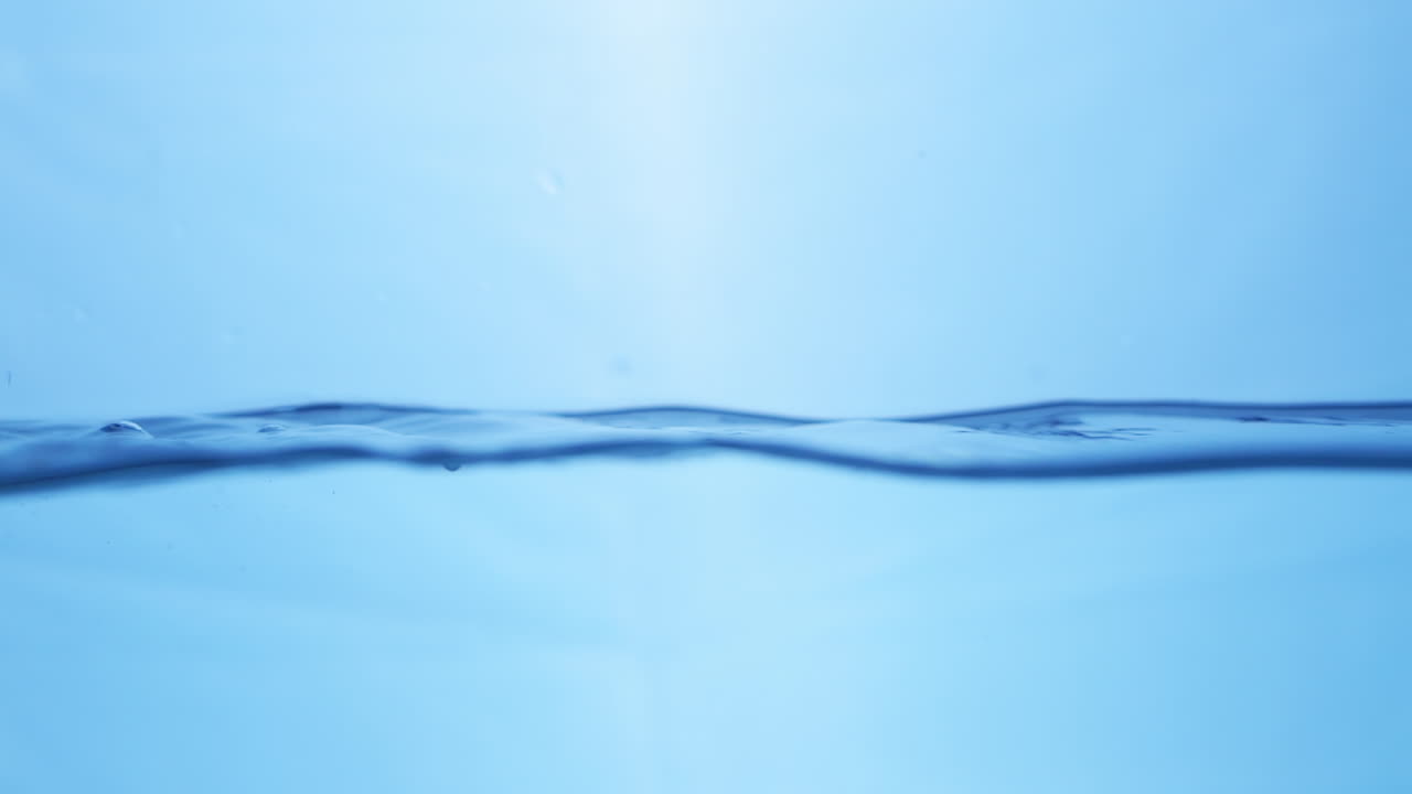 파란색 배경으로 표면에 있는 물의 파도_ 느린 움직임