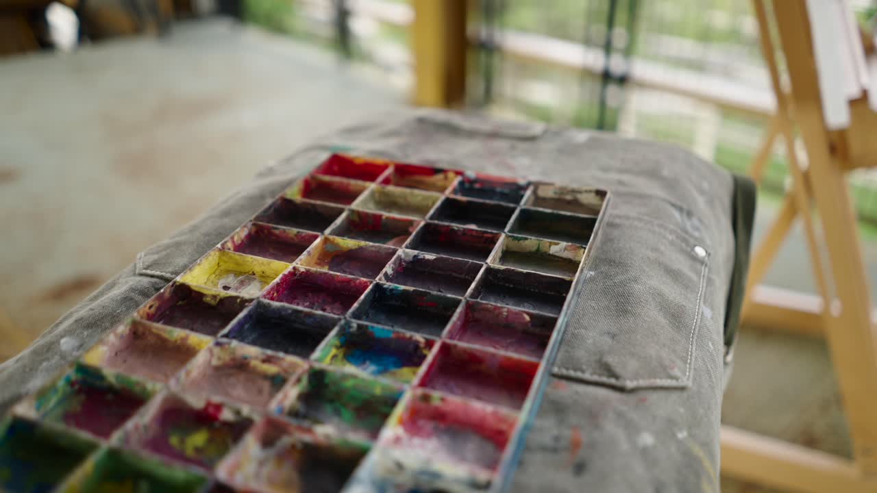 Close-up of a well-used paint palette with various colors