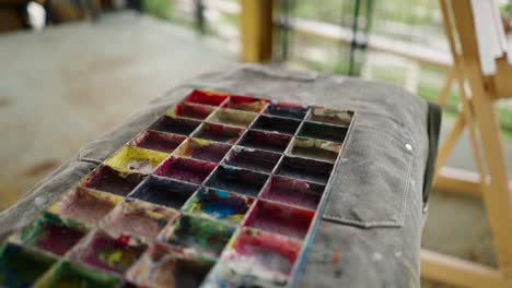 close-up of a well-used paint palette with various colors