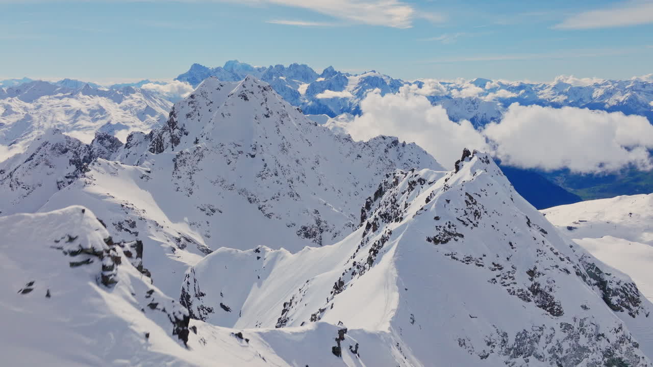Aerial footage of the iconic freeride paradise of Verbier on a stunning bluebird day. Snow-covered peaks, wide open faces, and legendary off-piste terrain under clear alpine skies