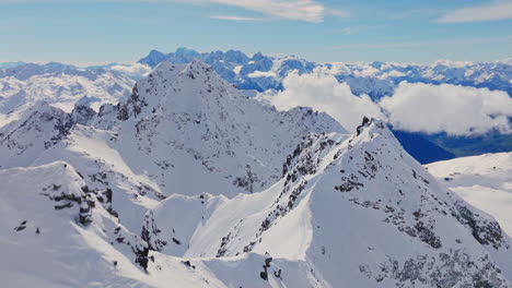 aerial footage of the iconic freeride paradise of verbier on a stunning bluebird day. snow-covered peaks, wide open faces, and legendary off-piste terrain under clear alpine skies