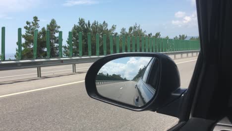 viajes en coche en la carretera, una vista del espejo retrovisor lateral, reflejo en el espejo. vista de la bahía desde el coche. primer plano.