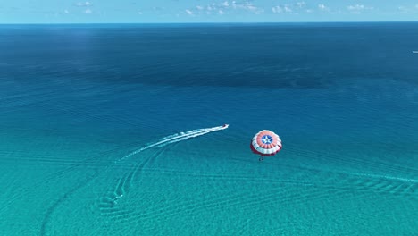 Vista-Aérea-Siguiendo-A-La-Gente-Haciendo-Parapente-En-La-Costa-Del-Soleado-Cancún,-México