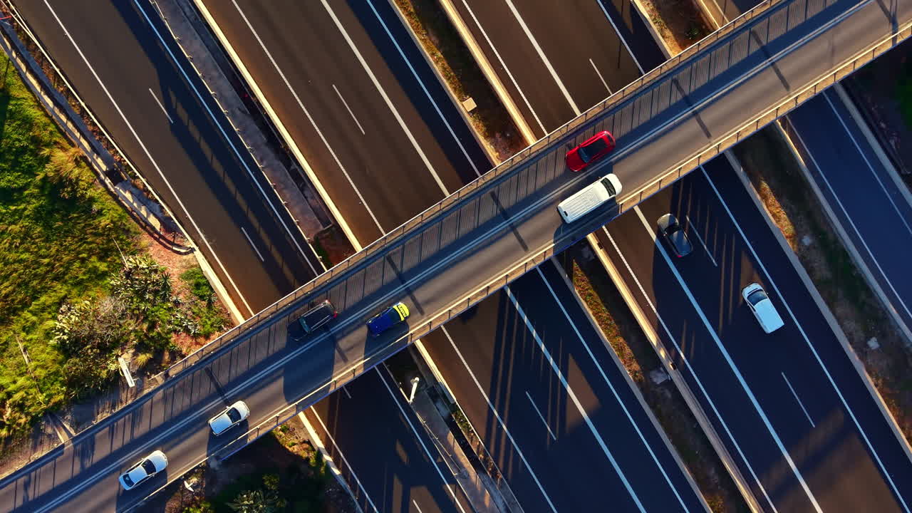 Traffic flows over roadways in a busy urban area during daylight on a clear day with multiple lanes merging and diverging