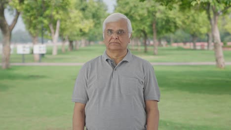 indian old man staring at the camera in park