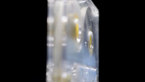 rotating yellow transparent audio cassette on a black background