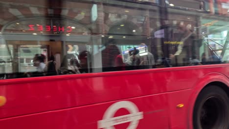 red bus traveling through london city street