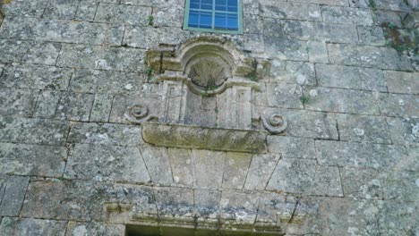 Green-painted-doors-at-entrance-of-old-church-pan-up-to-effigy-area-with-no-statue