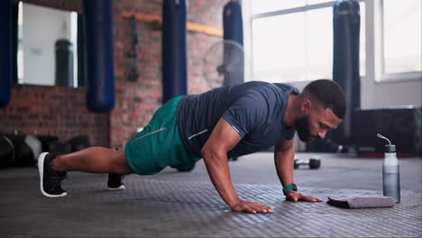 hombre haciendo flexiones en un gimnasio