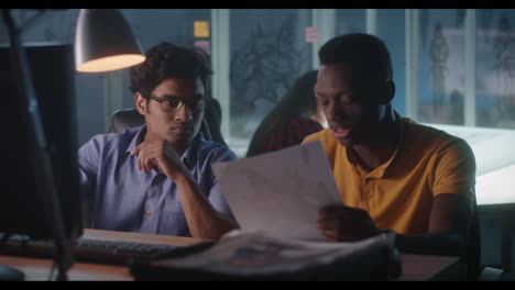 two colleagues reviewing documents at night