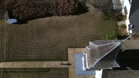 4k aerial footage of person leaving an old wooden prairie church in rural alberta
