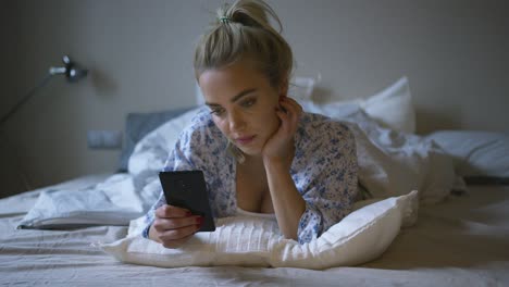 linda mujer usando un teléfono inteligente en la cama