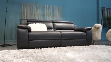 slow arching shot of a black leather couch for sale in a sofa shop