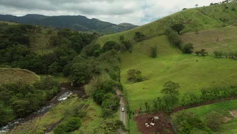 rural green landscape of costa rica with car driving on dirt road