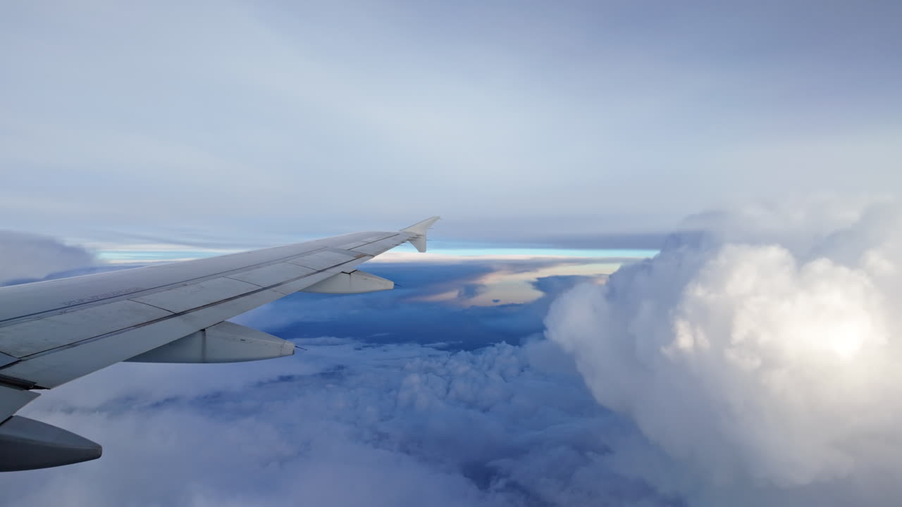 Airplane wing view above clouds at sunset evokes adventure and calm