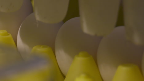 primer plano de huevos que caen en bandejas en una línea de producción