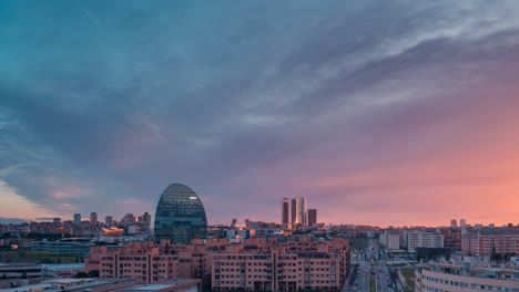 horizonte de la ciudad europea moderna madrid durante la puesta de sol con luz dorada y nubes rojas durante la hora azul zoom en día a noche time lapse bbva tower y 5 towers área de negocios rascacielos