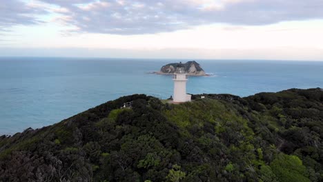 aerial view of east cape lighthouse on otiki hill with whangaokeno in the distance in new zealand