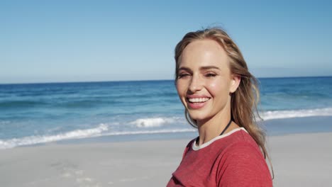 Woman-standing-on-the-beach-and-looking-at-camera-