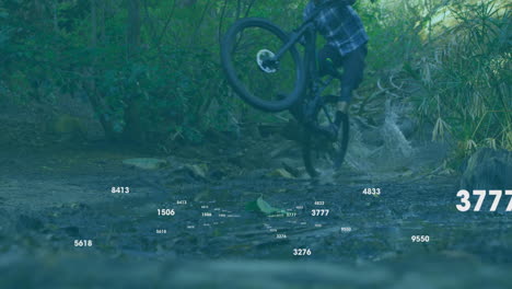 male cyclist performing wheelie on mountain trail, displaying health metrics with heart icon