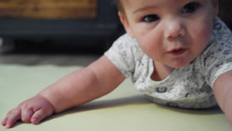 Baby-boy-smiling-on-the-ground-while-on-his-stomach-learning-how-to-crawl