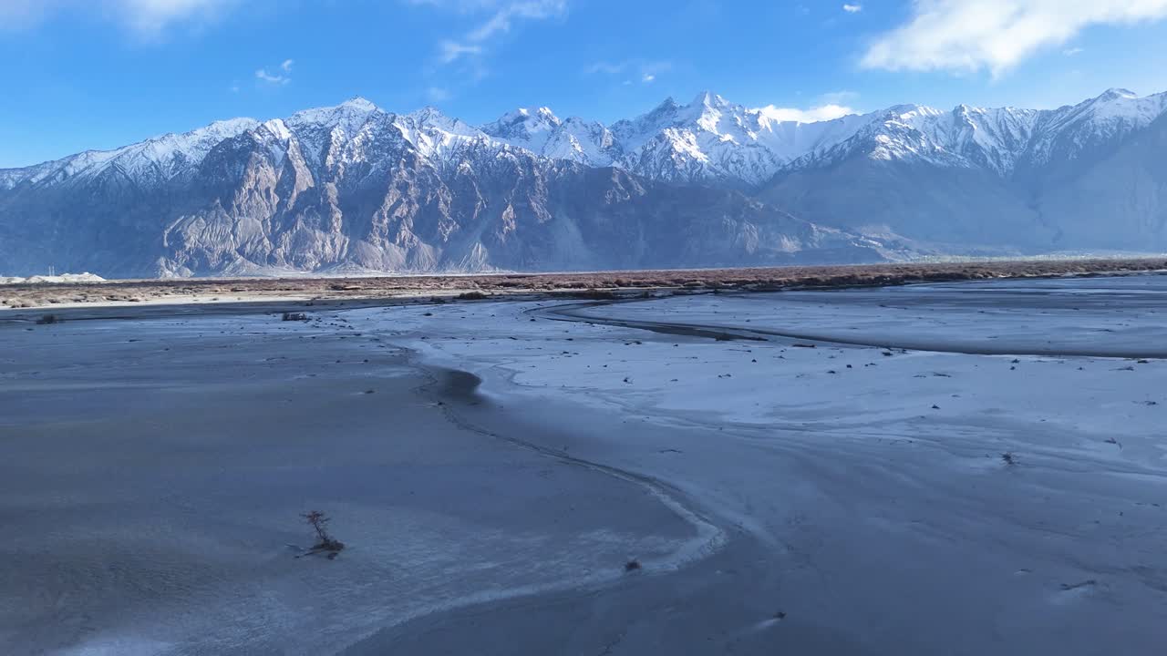 Aerial drone shot capturing the winding roads leading to Sumur village, set against Ladakh’s dramatic mountain backdrop.