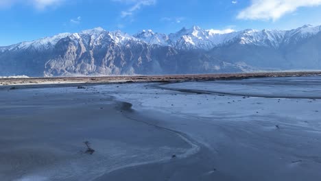 aerial drone shot capturing the winding roads leading to sumur village, set against ladakh’s dramatic mountain backdrop.