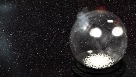 Animation-of-snow-falling-over-christmas-snow-globe-on-black-background