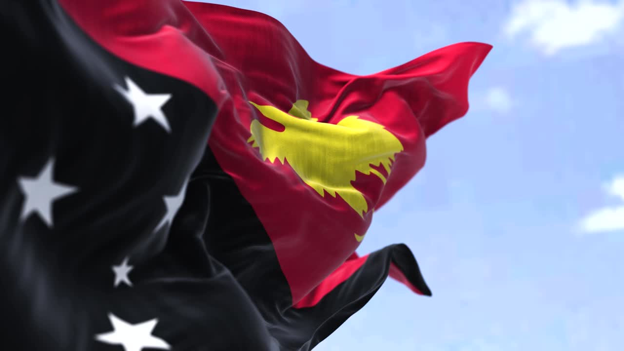 パプア・ニューギニアの国旗が晴れた日に吹き飛ぶ