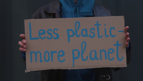 close-up view of a cardboard placard with the phase less plastic