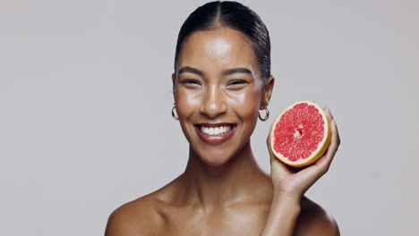 woman holding grapefruit