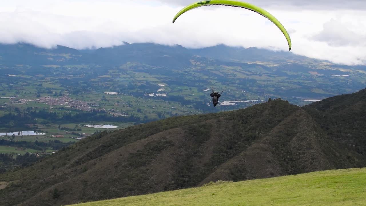 Man doing paragliding takeoffs and fly in a beautiful mountain