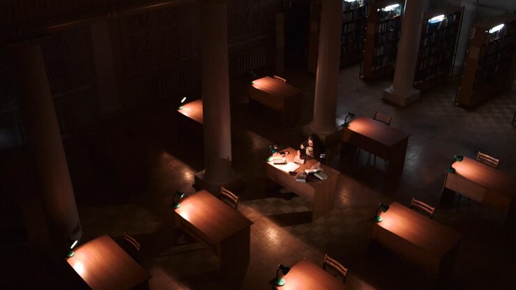 Studerende studerer i et mørkt bibliotek