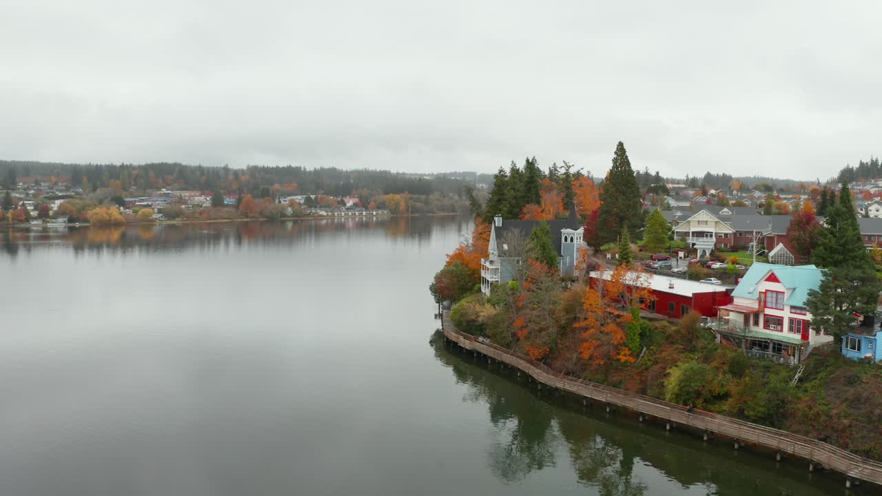 미국 워싱턴에 있는 호수 해안선에 있는 다채로운 주택과 교회의 총에 공중 돌리