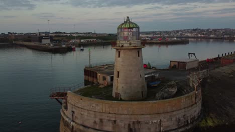 holyhead admiralty pier lighthouse aerial view passing industrial tower beacon coastline at sunrise