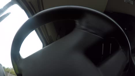 in cab action cam view of a male hgv driver maneuvering a articulated lorry around a roundabout