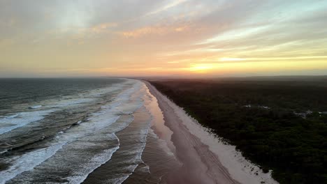 sunset casting a warm glow over a deserted beach, the coastline adorned by the day’s last light